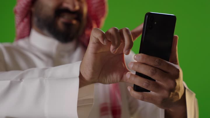 Saudi Man Using Smartphone Green Screen Close-up