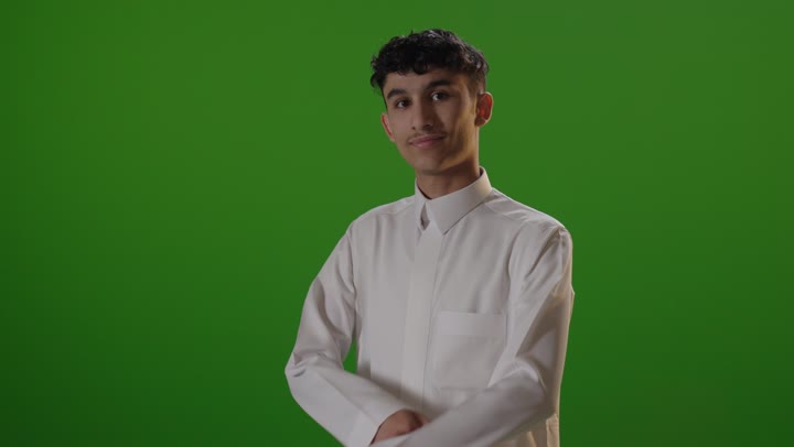 شاب عربي يرتدي الثوب الأبيض أمام خلفية كروما خضراء للاستوديو