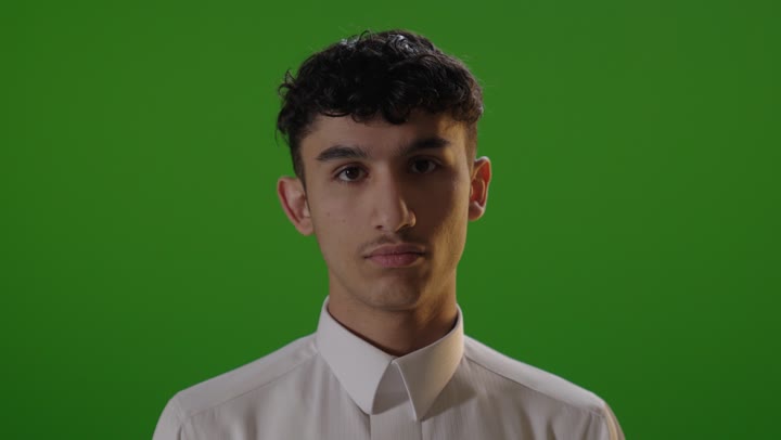 شاب عربي يرفع إبهامه أمام خلفية خضراء كروما