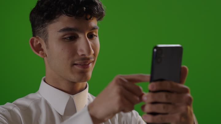 Young Arab Man Using Smartphone on Green Screen