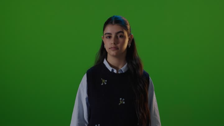 طالبة تشير بعدم الإعجاب أمام شاشة خضراء