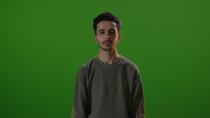 رجل يقوم بإيماءة الإبهام للأسفل على شاشة خضراء