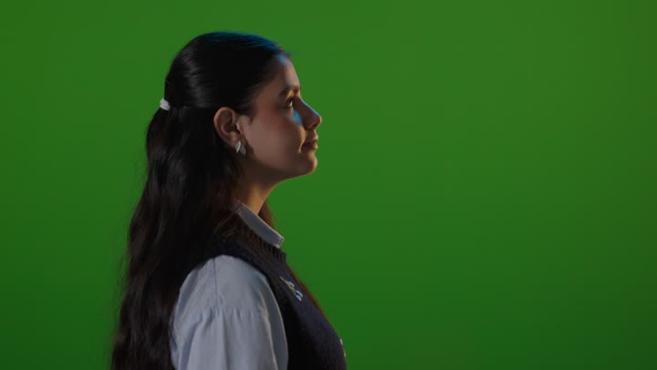 امرأة عربية تبتسم أمام خلفية خضراء كروما في استوديو