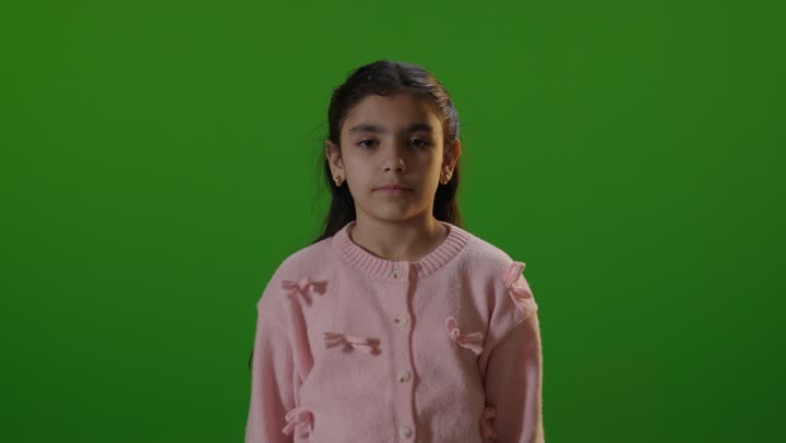 طفلة عربية تبتسم أمام خلفية كروما خضراء