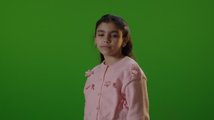 طفلة عربية تبتسم أمام خلفية كروما خضراء