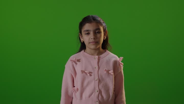 إيماءة طفلة بالرفض أمام الشاشة الخضراء