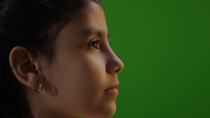 بورتريه طفلة عربية تبتسم أمام شاشة خضراء