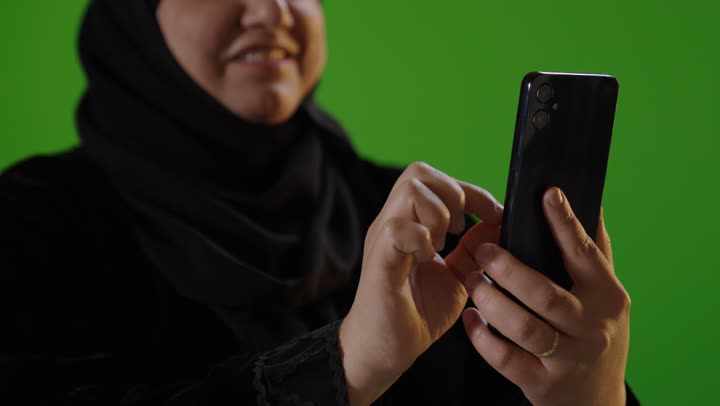 Saudi Woman Using Smartphone on Green Screen