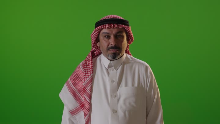 رجل سعودي يقوم بإيماءة الرفض أمام خلفية خضراء