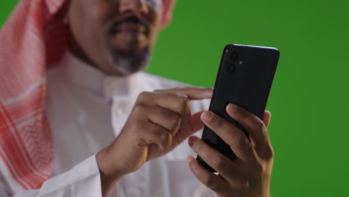 Saudi Man Using Smartphone on Green Screen Background