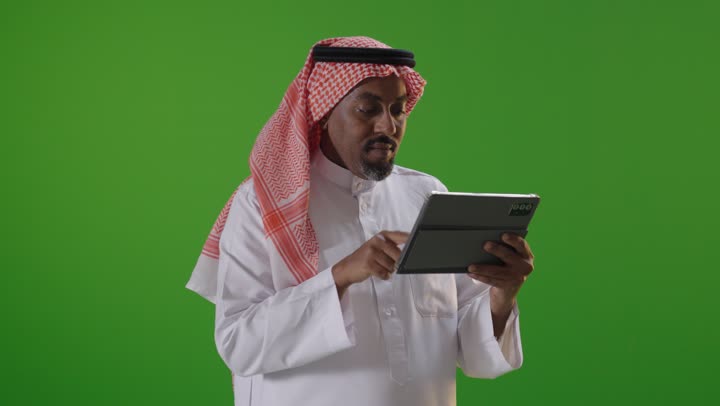 Saudi Man Using Tablet with Surprised Expression Green Screen