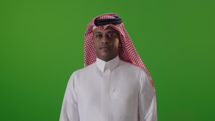 رجل سعودي بالثوب التقليدي أمام خلفية خضراء