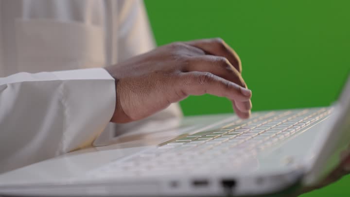 Saudi Man Typing on Laptop Green Screen Close-up