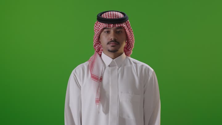 رجل سعودي بالزي التقليدي أمام خلفية خضراء