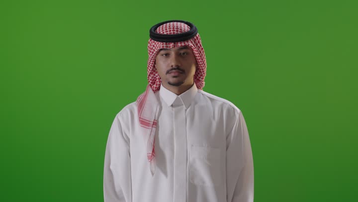 رجل سعودي أمام خلفية خضراء يرتدي الزي التقليدي
