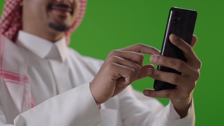 Saudi Man Using Smartphone on Green Screen Background