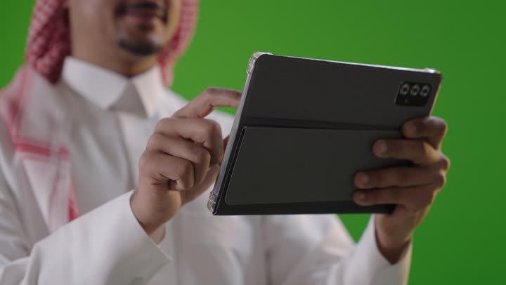 Saudi Man Using Tablet on Green Screen Background