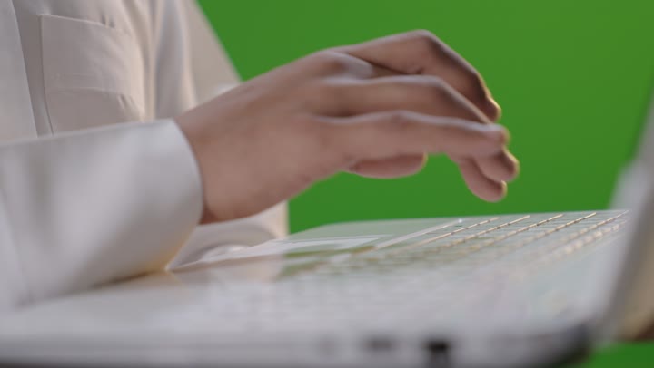 رجل سعودي يكتب على لابتوب كروما خضراء