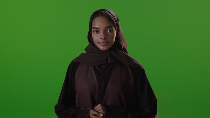 Saudi Woman in Brown Abaya Smiling on Green Screen Studio