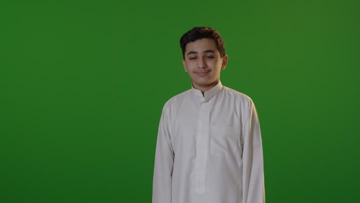 فتى سعودي يبتسم أمام خلفية شاشة خضراء كروما