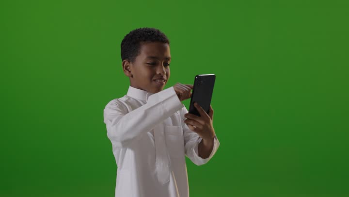 Saudi Boy Using Smartphone on Green Screen