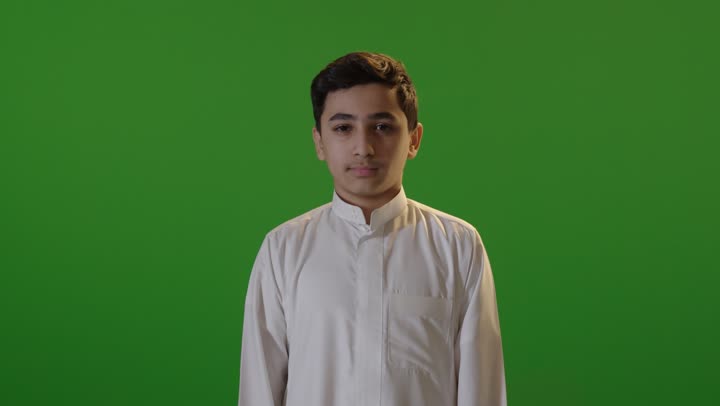 ولد سعودي بالثوب يشير بعدم الإعجاب خلفية خضراء