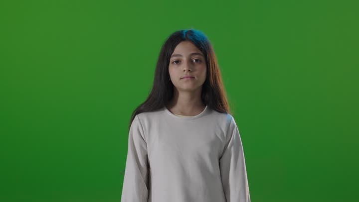 فتاة سعودية تبتسم أمام الكروما الخضراء في الاستوديو