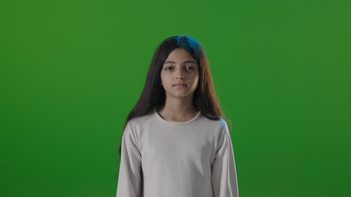 طفلة سعودية تؤدي إشارة الإعجاب خلفية خضراء