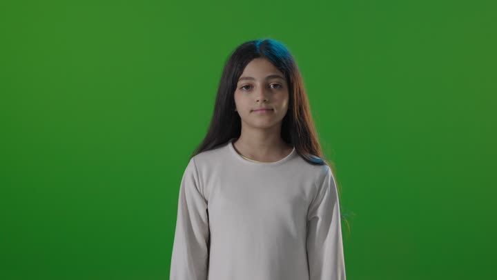 طفلة سعودية تشير بالإبهام للأعلى أمام كروما خضراء