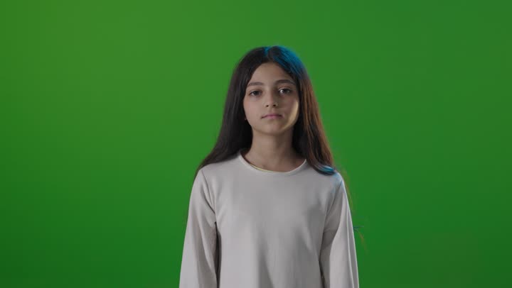 طفلة سعودية تقوم بإشارة الإبهام لأسفل خلفية خضراء