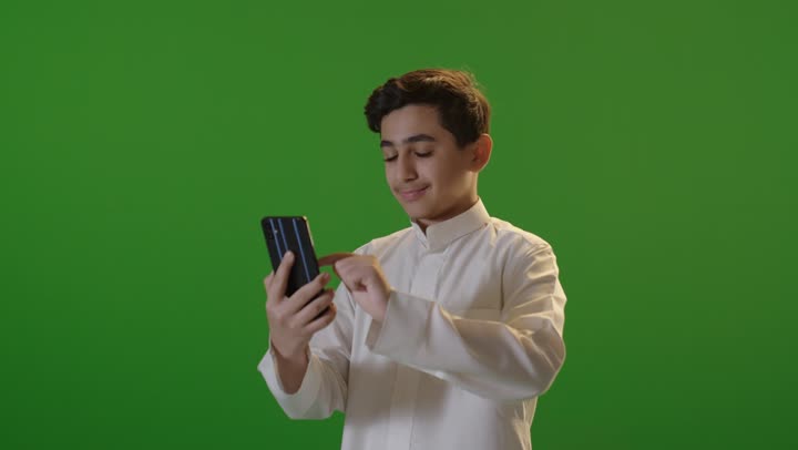 Saudi Boy Using Smartphone on Green Screen Background