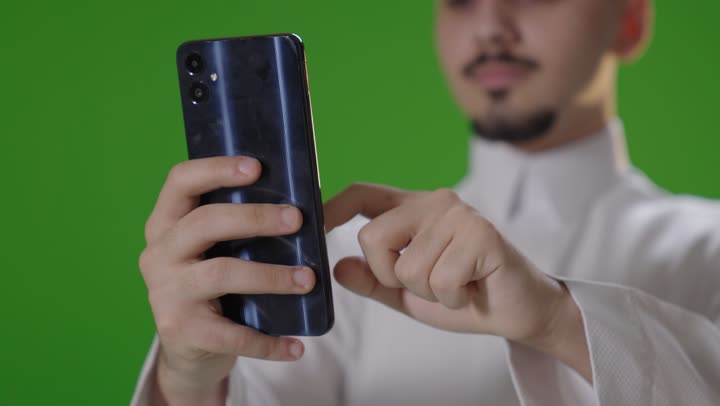 Saudi Man Using Smartphone on Green Screen Background