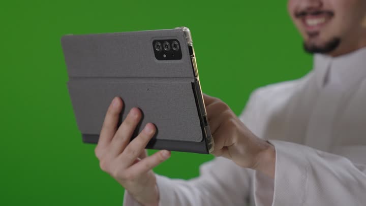Saudi Man Using Digital Tablet on Green Screen Background