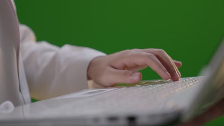 رجل سعودي يكتب على الكمبيوتر كروما خضراء