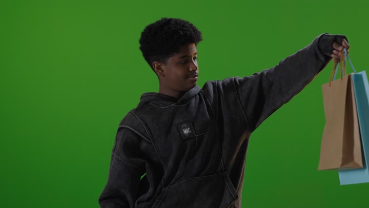 ولد سعودي يحمل حقائب تسوق كروما خضراء