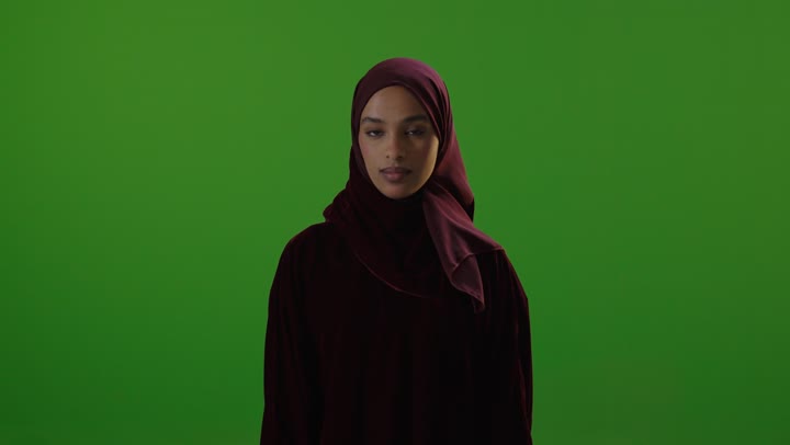 امرأة سعودية تشير بالإبهام للأعلى أمام خلفية خضراء