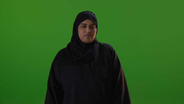 امرأة سعودية بالعباءة تؤيد بعلامة الإبهام كروما خضراء