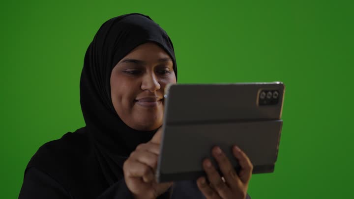 Saudi Woman Using Tablet on Green Screen Background