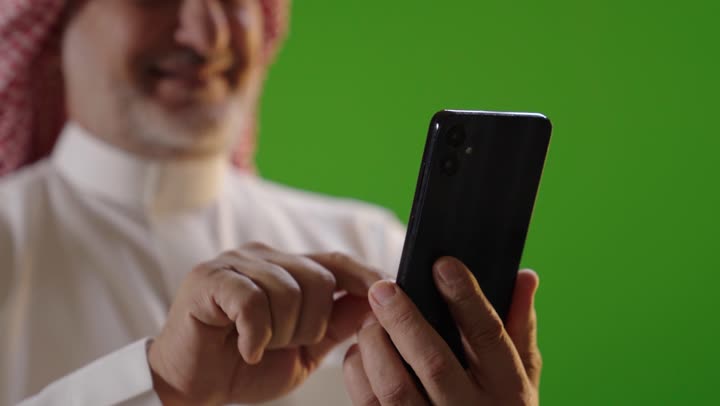 Saudi Man Using Smartphone on Green Screen Background