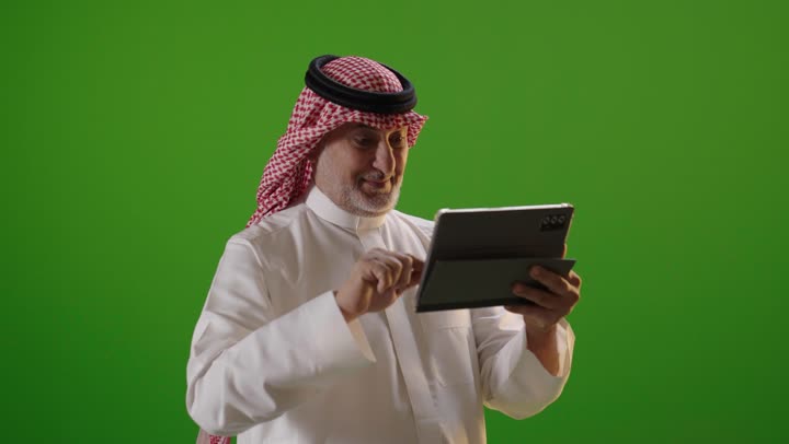 رجل سعودي يستخدم جهاز لوحي كروما خلفية خضراء