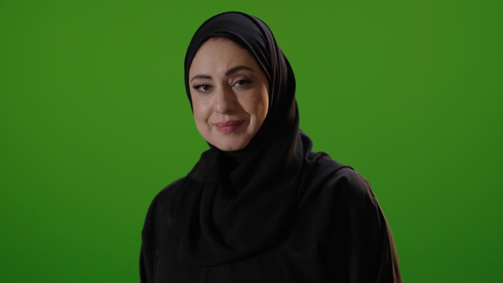 امرأة سعودية بالعباءة أمام خلفية خضراء كروما