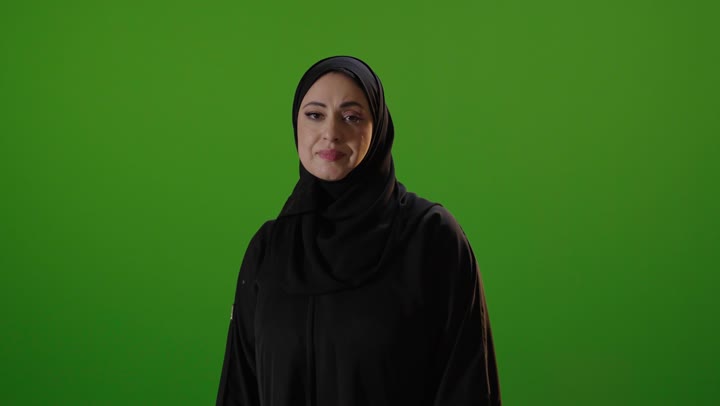 امرأة سعودية تشير بالرفض أمام خلفية كروما خضراء