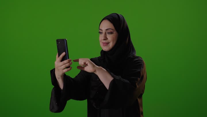 Saudi Woman Scrolling on Smartphone over Green Screen