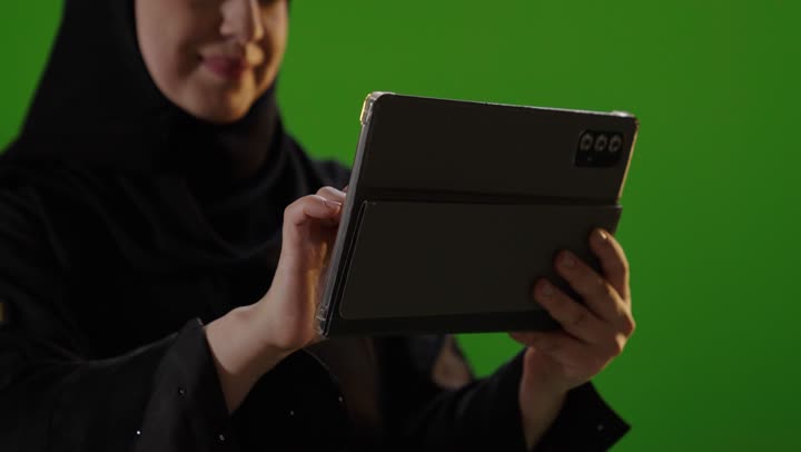 Saudi Woman Using Digital Tablet on Green Screen