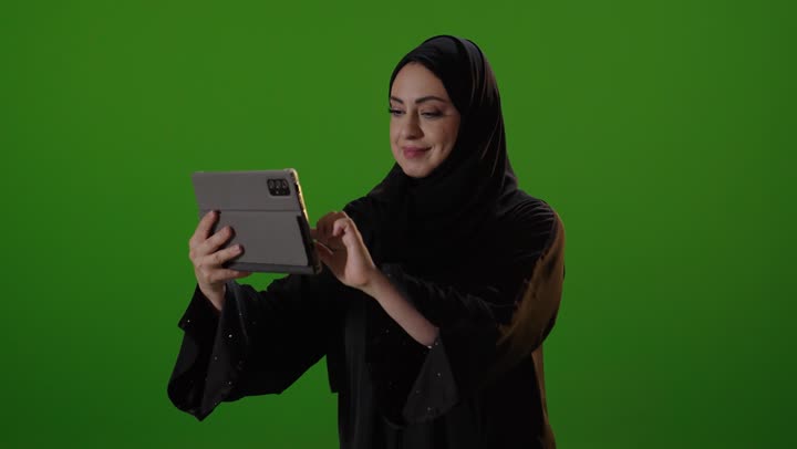 Saudi Woman Using Digital Tablet on Green Screen
