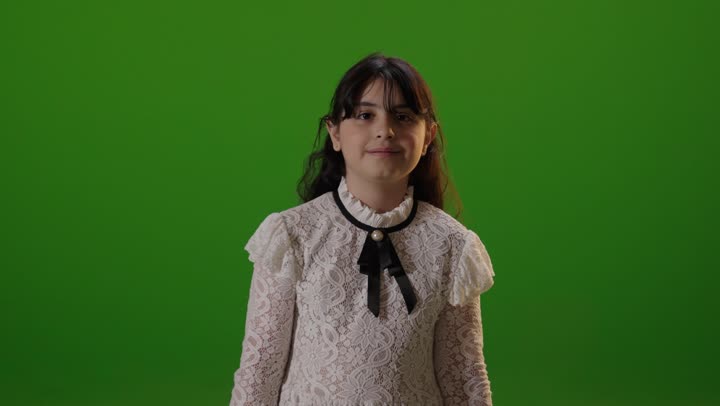 بورتريه طفلة سعودية تبتسم أمام خلفية كروما خضراء