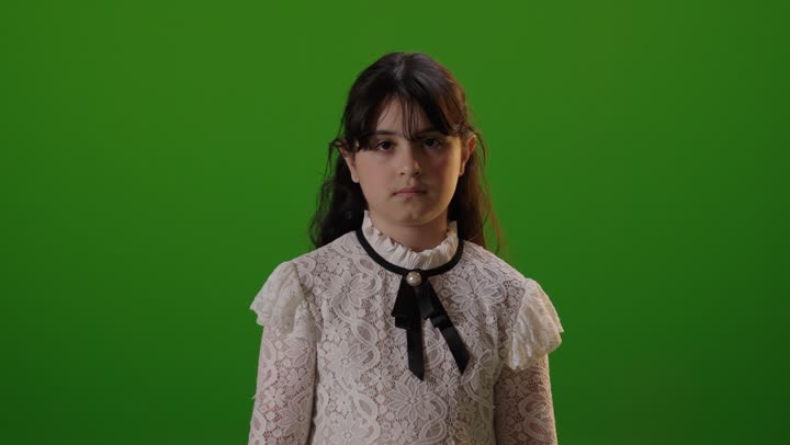 طفلة سعودية تبتسم أمام خلفية كروما خضراء