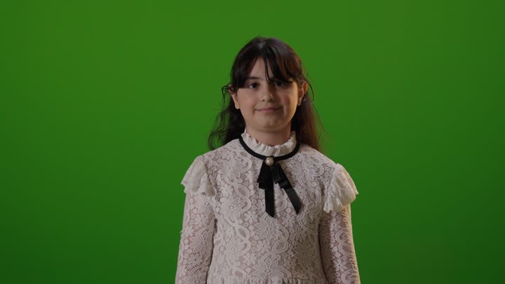 طفلة سعودية تشير بالإبهام أمام خلفية خضراء