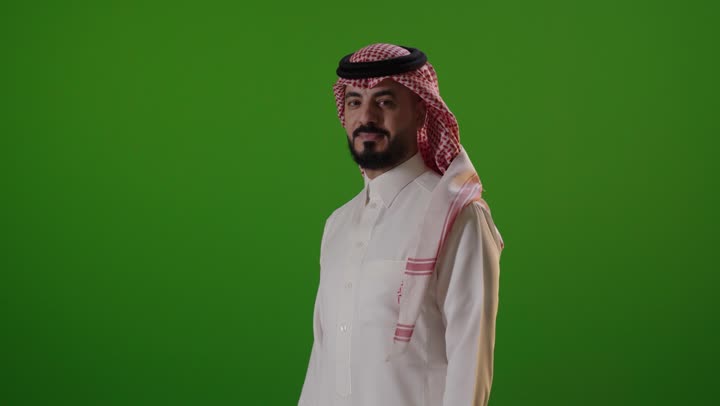 رجل سعودي بالزي التقليدي أمام خلفية خضراء