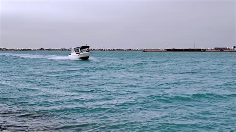 قارب بمحرك أبيض يسير بسرعة في البحر الساحلي في ينبع